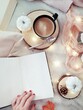 © RooM The Agency - Woman's hand holding open a blank notebook and a cup of coffee with decorations