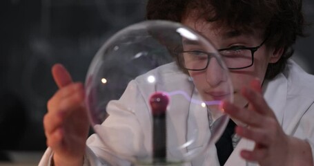 Wall Mural - schoolboy experimenting in physics class. young student doing physics experiment in the classroom