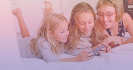 three caucasian sisters using smartphone together while lying on the bed