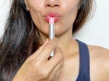 Woman Wearing Lip Gloss On Her Lips In White Background. Used As Lips Treatment. Health And Beauty Concept.