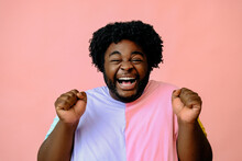 Young Happy African American Man Posing In The Studio Over Pink Background