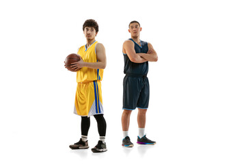 Portrait of two young basketball players posing isolated on white studio background. Motion, activity, sport concepts.