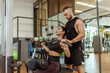 © splitov27 - Young fit woman training muscles with personal trainer man in the gym