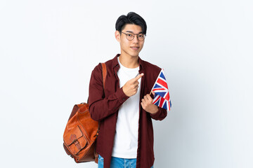 Poster - Chinese man holding an UK flag isolated on purple background pointing to the side to present a product