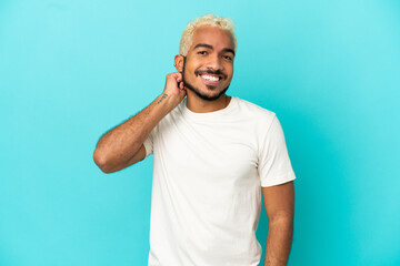 Canvas Print - Young Colombian handsome man isolated on blue background laughing