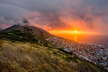 A dramatic sunset over Cape Town with the Lion's Head summit in clouds.