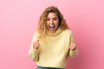 Wall Mural - Young blonde woman isolated on pink background celebrating a victory in winner position