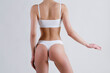 © Evrymmnt - Close up shot of unrecognizable fit woman in lingerie isolated on white background. Cropped shot of lower half of slim attractive female's body in white underwear. Copy space for text.