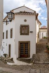 Poster - vertical view of a cobblestone street and historic whitewashed houses in the old city center of Marvao