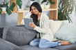 © Arnéll Koegelenberg/peopleimages.com - These modern-day sites can sure make ones day. Shot of a happy young woman using her digital tablet while relaxing on her couch at home.