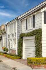 Wall Mural - Front of a house that is white, has windows and an ivy plant that is surrounding the car garage