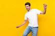 © deagreez - Photo of cute young brunet guy dance wear casual cloth isolated on yellow color background