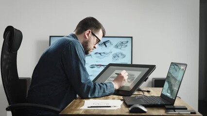 Industrial design studio with graphic tablet and computers. A senior designer draws a new car concept on a tablet.