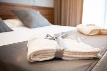 Poster - A White bathrobe on the bed of room  hotel