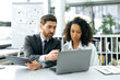 © Kateryna - Successful colleagues, office workers, financial consultants, economists, sit in front of a laptop screen, in a modern office, develop a working strategy, analyze data, discuss the work concept