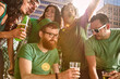 © SuperStock - Friends all gathered around a table dancing and drinking beer at party on St Patrick's Day