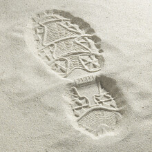 Close-up Of A Shoe Print In The Sand At The Beach