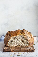 Fresh homemade bread (slice) from whole grain sourdough flour with the addition of bran, seeds (sunflower, pumpkin, flax, sesame) and oatmeal flakes. Healthy food. High quality photo.