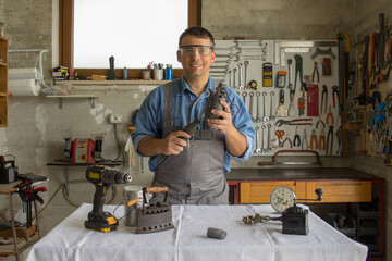 Wall Mural - Smiling man in his workshop while restoring antiques.