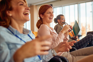 two cheerful female colleagues having fun during a business lecture in the conference room. business