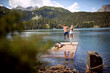 © luckybusiness - A young couple is jumping into the lake during mountain hiking on a beautiful day. Trip, nature, hiking