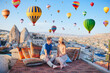 © travnikovstudio - Happy young couple during sunrise watching hot air balloons in Cappadocia, Turkey