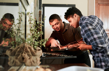 Wall Mural - Theyre best friends who always grill together. Shot of two young men grilling meat while having a barbecue.