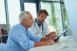 © Katleho Seisa/peopleimages.com - Working together to get him back to the best health. Shot of a handsome doctor going over some paperwork with a male senior patient in a clinic.