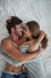 © Adene S/peopleimages.com - Youre the beautiful part of my life. High angle shot of a happy young couple cuddling together in bed.