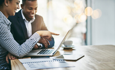 Poster - Getting their tasks all in order. Shot of two businesspeople working together on a laptop in an office.