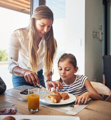 Sticker - Let me help you with that, my angel. Shot of a mother having breakfast with her little daughter at home.