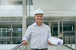 © Camerene P/peopleimages.com - The boss with the plan. Portrait of a cheerful professional male architect looking at the camera while holding blueprints inside a building.
