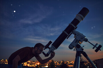 Wall Mural - silhouette of a man and telescope under the starry skies.