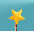 Successful and Talent Concept, Hand Raise up a Golden Star into the blue Sky