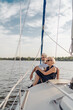 © luengo_ua - Romantic vacation and luxury travel. Senior loving couple sitting on the yacht deck. Sailing the river.