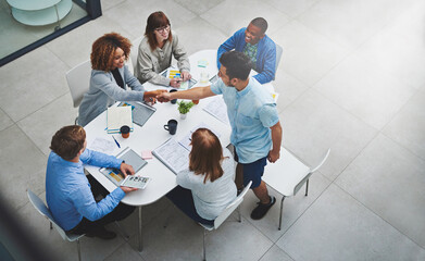 Fototapete - Youve earned this promotion. High angle shot of young businesspeople shaking hands during a meeting.