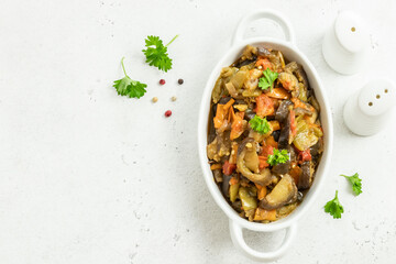 Healthy vegan dinner vegetable saute in baking dish. Space for text, top view