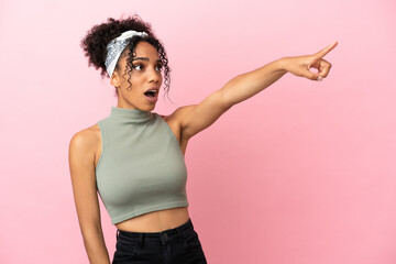 Sticker - Young latin woman isolated on pink background pointing away