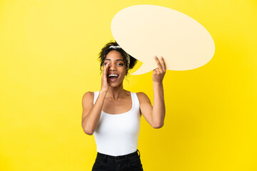 Sticker - Young african american woman isolated on yellow background holding an empty speech bubble and shouting