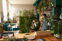 Adult Woman Looking At Round Mirror With Plants