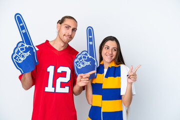 Young sports fan couple isolated on white background pointing finger to the side in lateral position