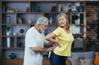 © Liubomir - Senior husband massaging his wife's back, gray-haired retired couple at home during fitness class