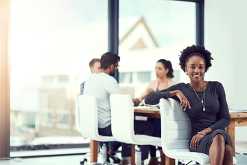 Wall Mural - im part of a great team. cropped portrait of a young woman sitting in the office with her colleagues