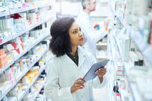 Mobile Apps That Have Pharmacy Management Covered. Shot Of A Young Woman Using A Digital Tablet To Do Inventory In A Pharmacy.