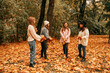 © Татьяна Волкова - Four young women staying preparing to throw maple leaves in the air. Having fun, enjoy promenade in orange autumn park
