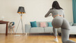 © shevtsovy - Young sporty woman doing squat morning exercise. home fitness routine. Woman with strong glutes workout at home. Female gymnastics. Butt workout motivation.