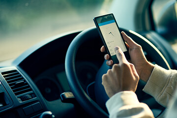 Canvas Print - Staying on schedule. Closeup shot of an unidentifiable delivery man using a cellphone while sitting in his van.