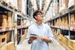 © Art_Photo - Portrait of smiling asian engineer foreman in helmets man order details checking goods and supplies on shelves with goods background in warehouse.logistic and business export