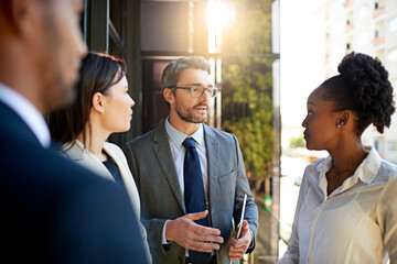 Poster - They never question his ideas. Shot of a diverse group of businesspeople having a meeting on a balcony in bright sunlight.