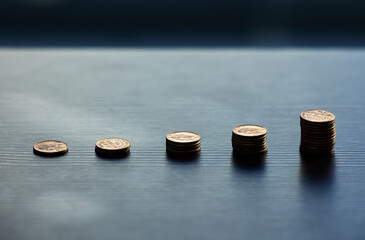 Grow your money fast. Shot of a bunch of coins on a table.